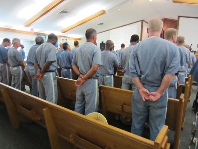 Chapel full of inmates attended a sermon.