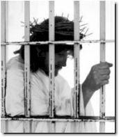 Photo of a person dressed as Jesus, wearing a cron of thorns, behind bars.