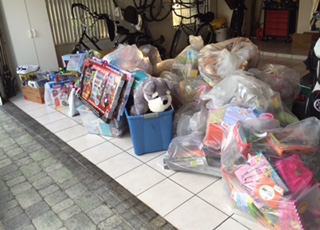 Massive jumble of toys in all different types of containers and bags delivered to a needy home.